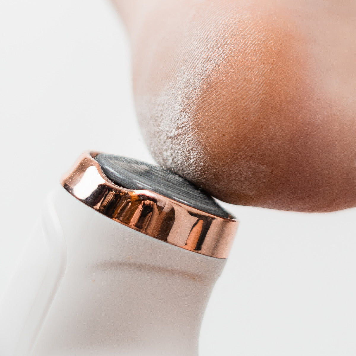 A close-up of the Rio Go Smooth Electric Foot File Hard Skin Remover with Vacuum Action exfoliating the heel, removing dry skin to reveal smooth feet.