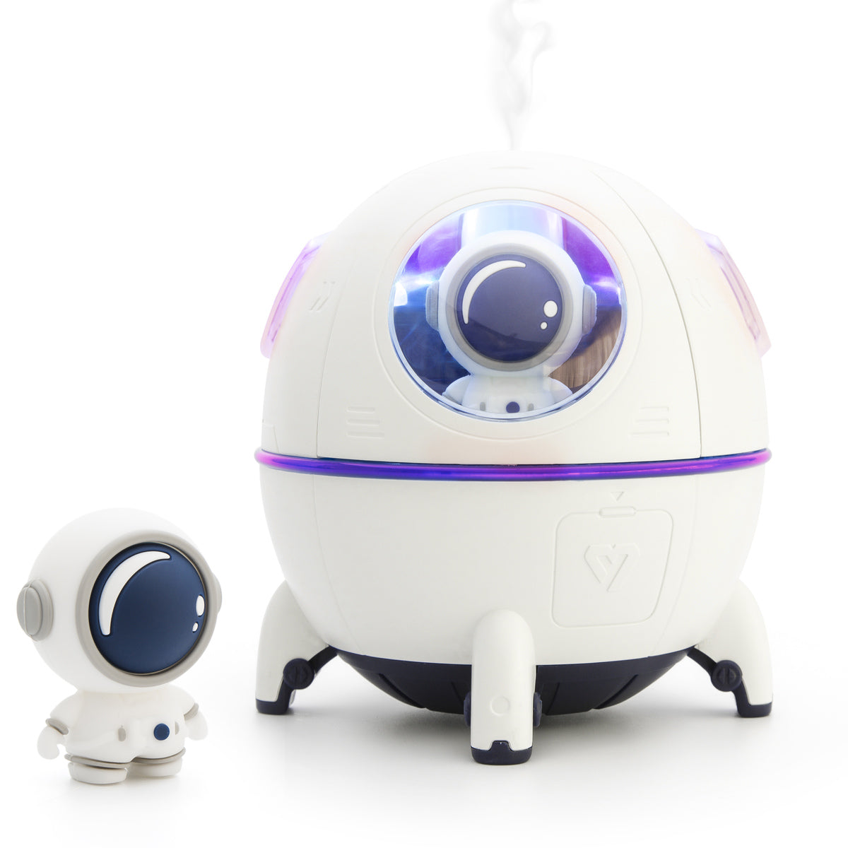 A small astronaut figurine stands by the Rio Spaceship Explorer Childs Essential Oil Diffuser, Humidifier and Night Light, which features a window, purple accent light, steam output, and a matching astronaut inside for a playful, futuristic touch.