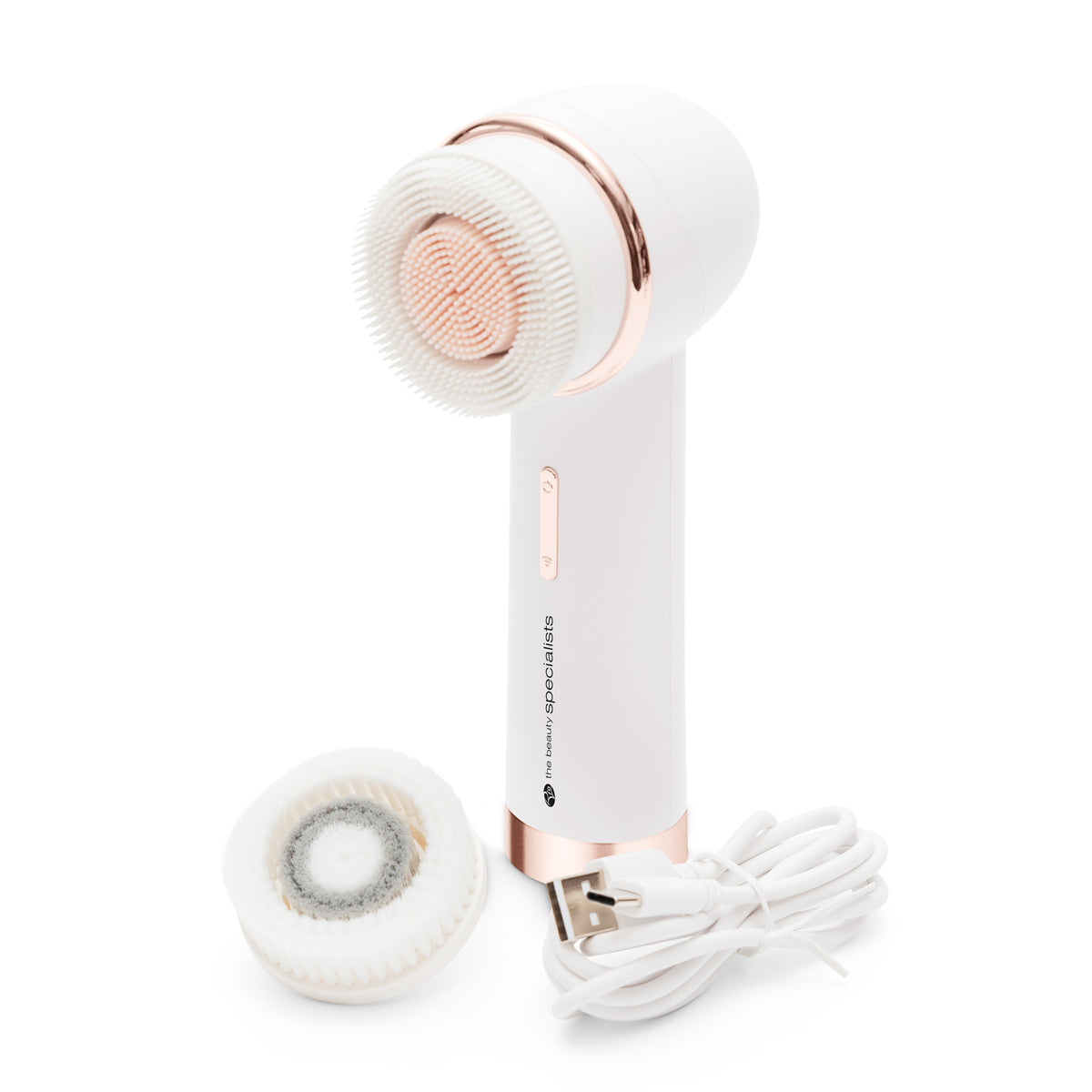 The PURE CLEANSE Deep Cleansing & Exfoliating Facial Brush by Rio the Beauty Specialists comes in white and rose gold, includes a bristle head, extra brush head, and a white charging cable—ideal for effective skincare.