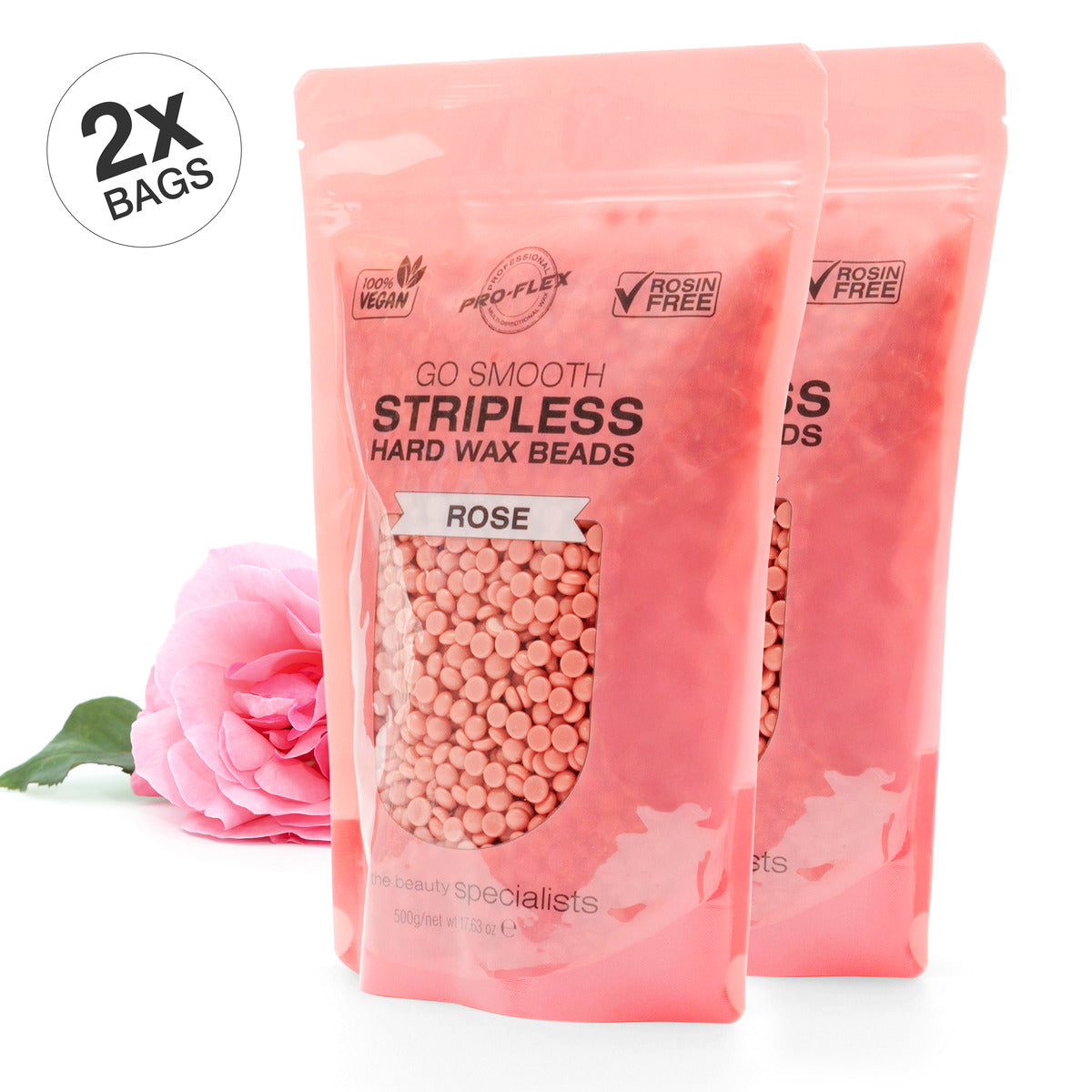 Two upright bags of Rio Rose Go Smooth Stripless Hard Wax Beads (500g) promise smooth skin. A pink rose lies beside them, while a circular label at the top left reads 2x Bags.