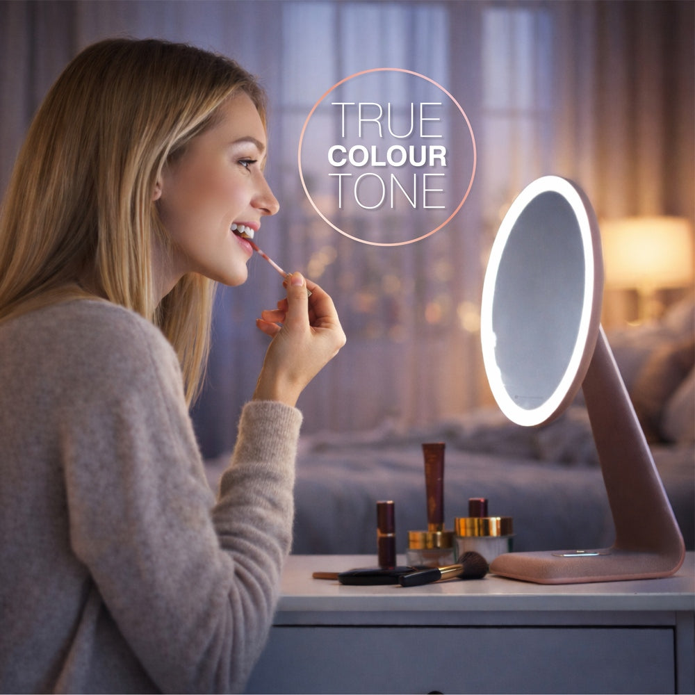 A woman applies lipstick at a vanity, looking into the Rio TrueColour High Performance Makeup Mirror. “TRUE COLOUR TONE” appears above the illuminated, round mirror in a softly lit, warm-toned room defined by refined simplicity and clarity.