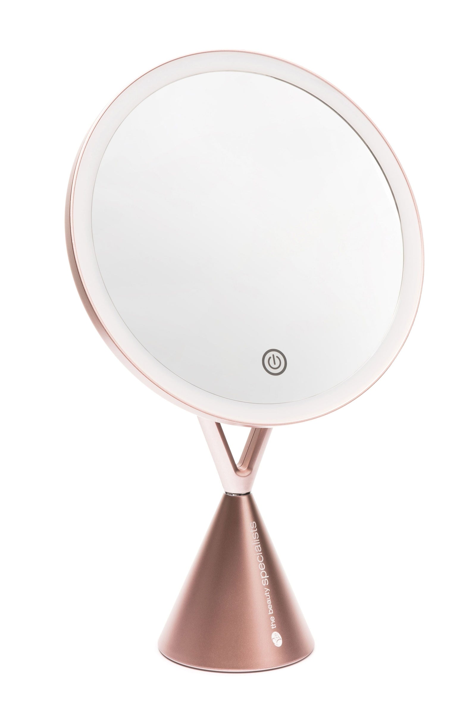 The Rio HD Illuminated Makeup Mirror features a round, rose gold design with built-in LED lighting, a touch power button, and a cone-shaped base. It includes an upright, backward-angled mirror and a compact magnifying accessory for detailed beauty tasks.
