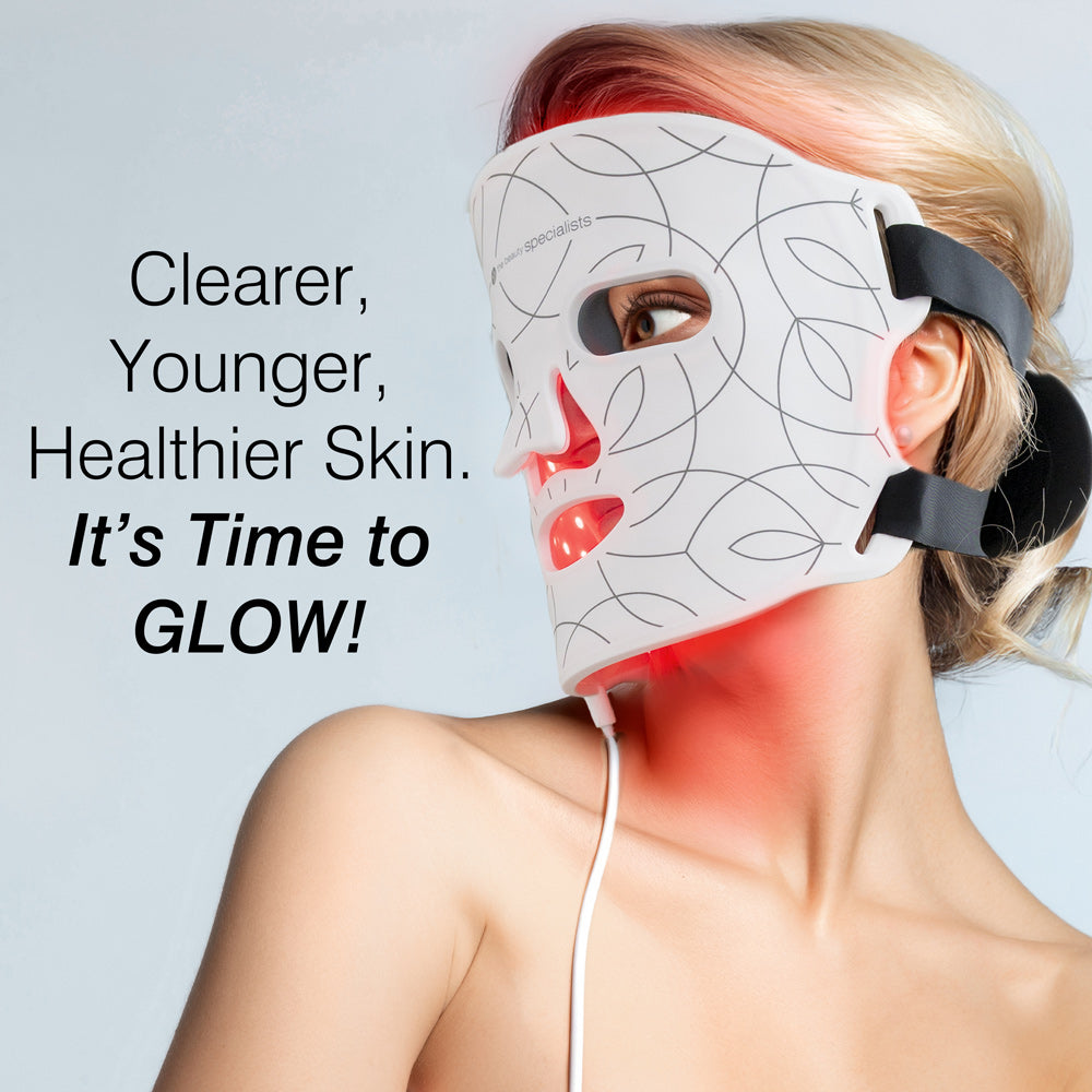 A woman wears the Rio LED Face Mask with black straps, looking to the side. The text reads: Clearer, Younger, Healthier Skin. It’s Time to GLOW! This patterned Rio mask uses red light therapy for powerful anti-ageing benefits.