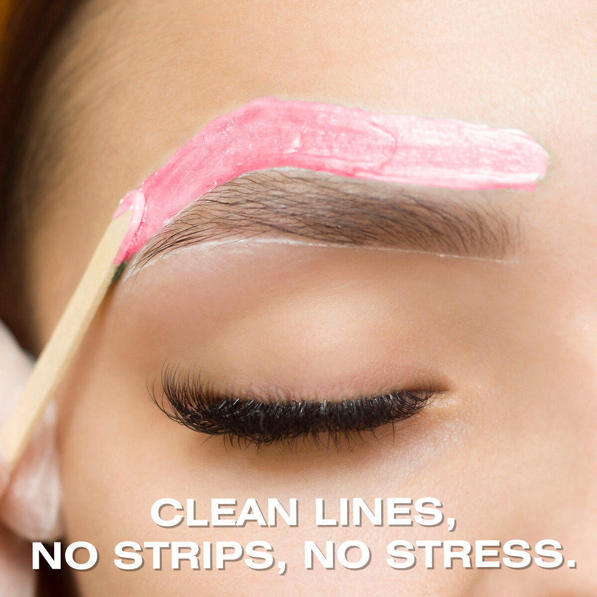 Close-up of Rose Go Smooth Stripless Hard Wax Beads (100g) by Rio being applied to an eyebrow with a wooden stick. The person’s eye is closed, with the text: CLEAN LINES, NO STRIPS, NO STRESS.