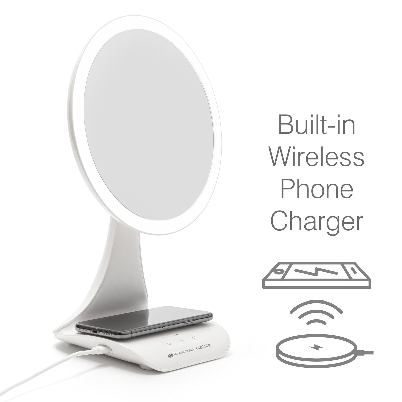 The Rio 5x magnification LED makeup mirror features a built-in wireless charging station at the base. A smartphone is placed on the charger, with icons and text beside the mirror stating Built-in Wireless Phone Charger.