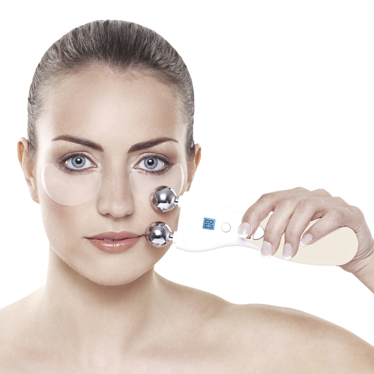 A woman with under-eye gel patches uses the Rio Lift Plus 60 Second Face Lift dual-ball massager on her cheek against a white background, highlighting facial rejuvenation.