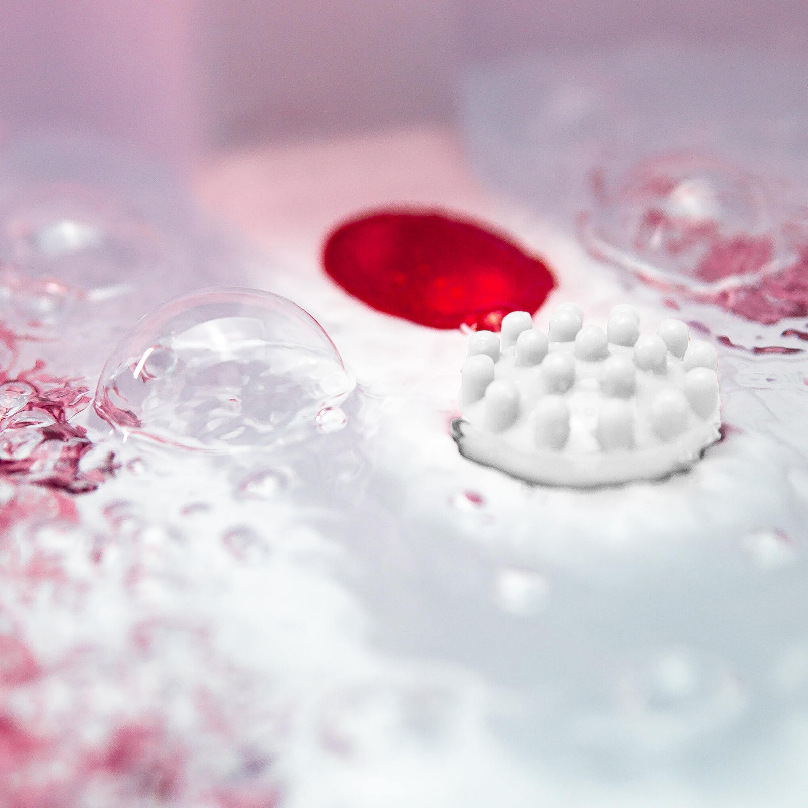 Close-up of the Soothing Waves Foot Bath Spa & Massager by Rio: a white, round device with raised bumps in soothing water and bubbles, creating an abstract, relaxing scene with soft lighting for indulgent foot care.