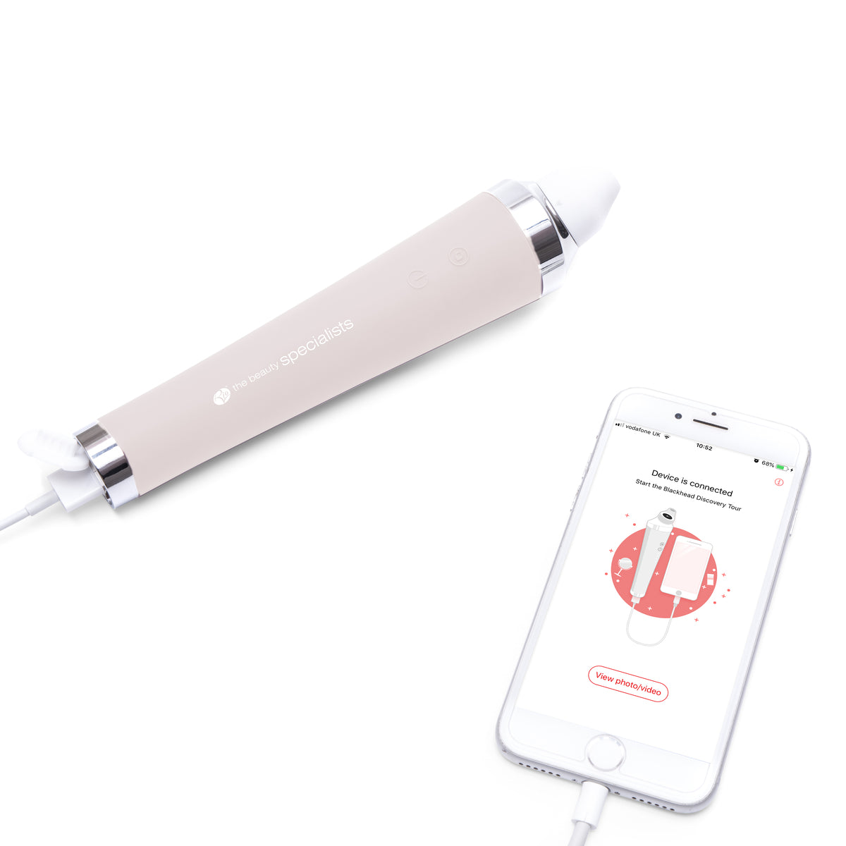 The Rio Pore Perfection, a white electronic handheld device with buttons for personalized skincare and pore cleansing, is shown connected by cable to a smartphone displaying its app interface, both resting on a white surface.