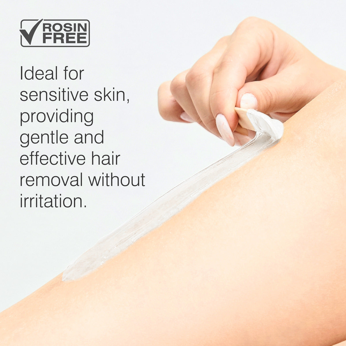 A hand peels Rio Coconut Go Smooth Stripless Hard Wax Beads (100g) from smooth skin, showing it’s rosin-free and ideal for sensitive skin, providing gentle, effective hair removal without irritation.