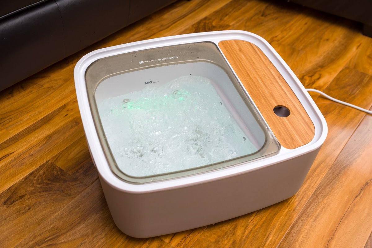 The Rio Scandinavian Jacuzzi Foot Spa Bath features bubbling water, a transparent lid, and wooden accents—plugged in and ready to deliver a luxurious at-home pedicure experience.