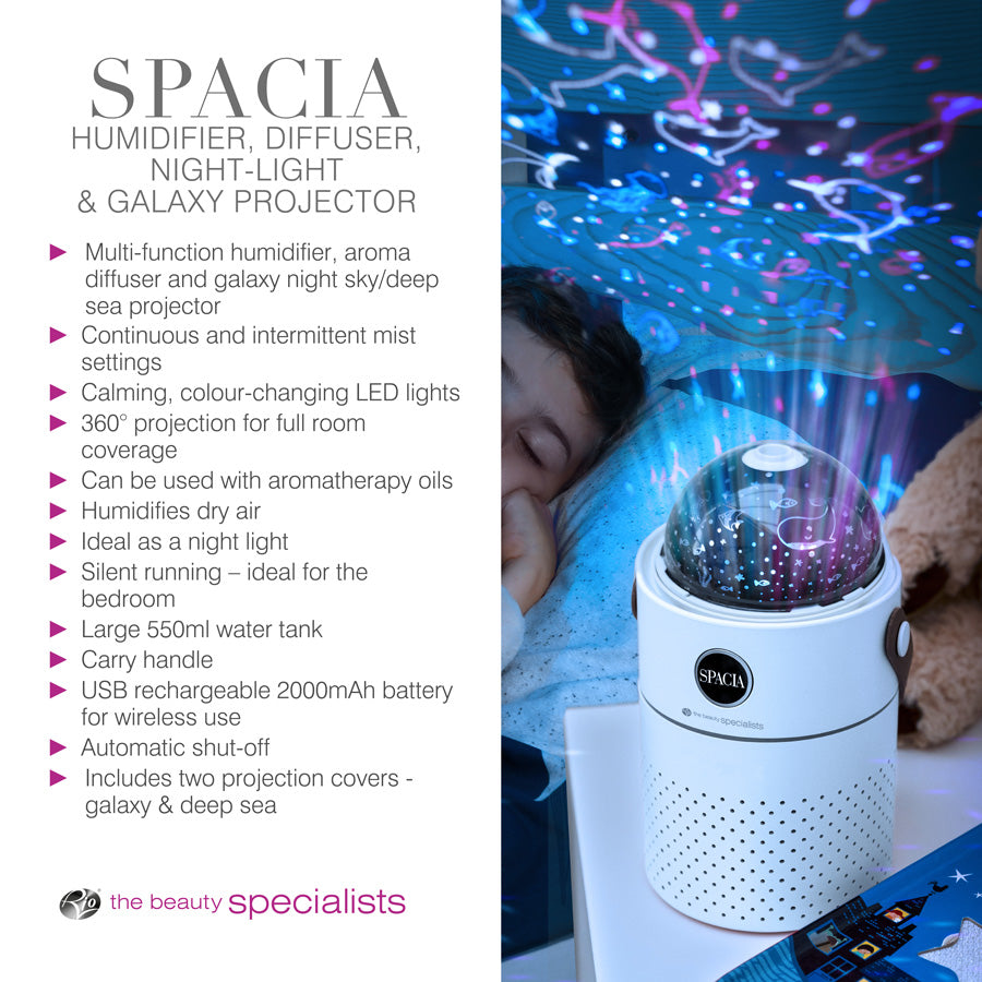 A child sleeps beside the Rio Galaxy Projector Childrens Essential Oil Diffuser, Humidifier and Night Light, which projects galaxy lights on the ceiling and features a 360° rotating projector, USB charging, and two projection covers.