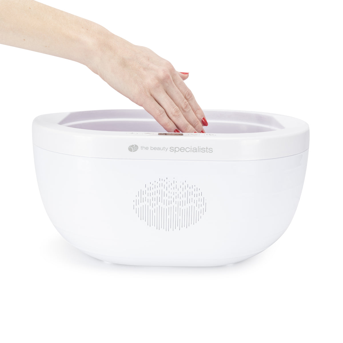 A hand with red nail polish is dipped into a white Rio Paraffin Wax Heater, offering comfort and enhancing skin hydration.