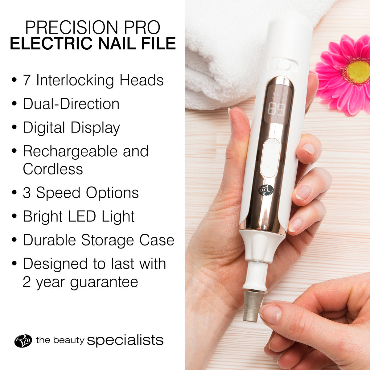 A hand holds the Rio Precision Pro Electric Nail File with digital display—ideal for pro nail care. Features: 7 interlocking heads, dual direction, rechargeable, 3 speeds, LED light, storage case & 2-year guarantee. Pink flower nearby.