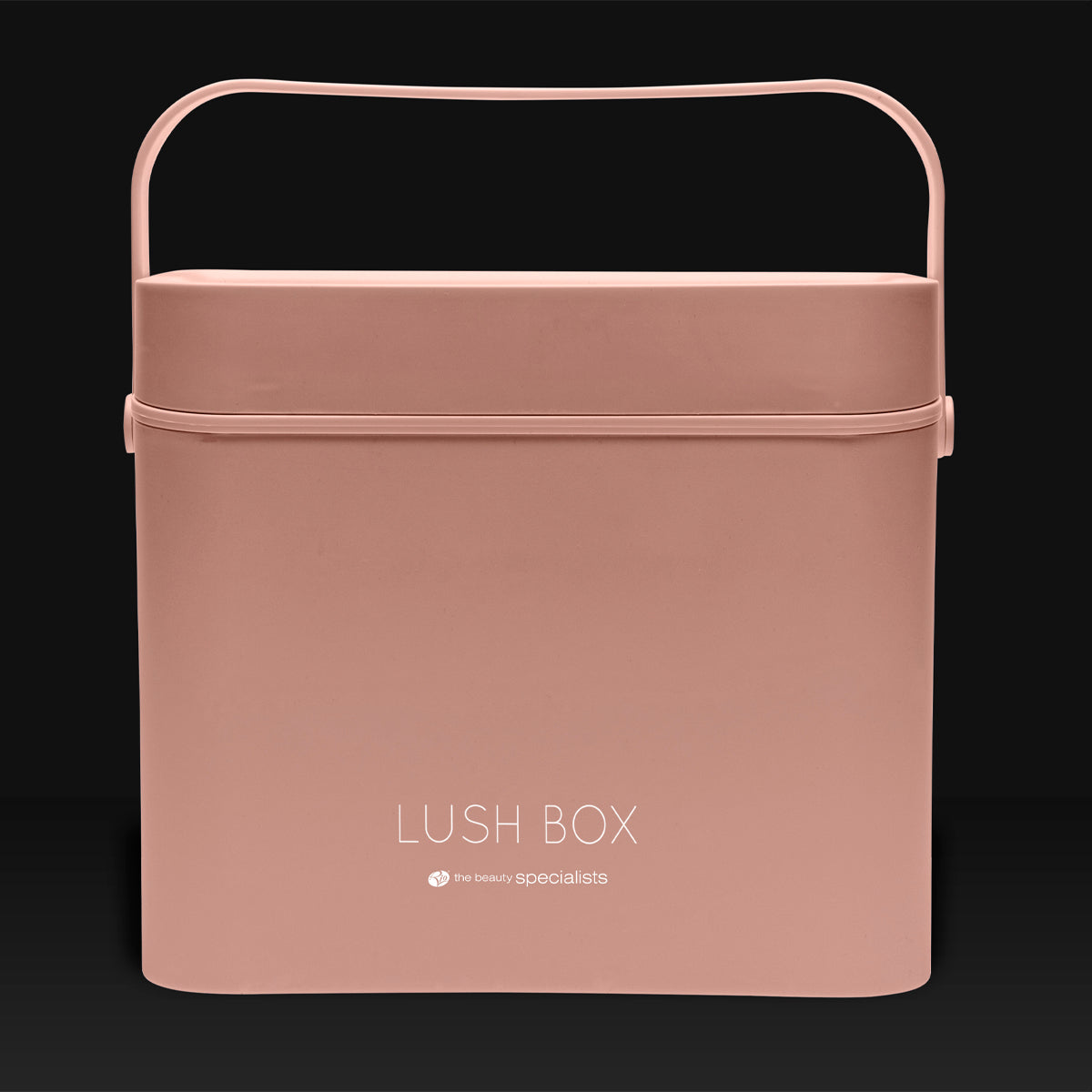 The Rio Lush Box Vanity Case - Large is a rectangular blush pink case with a handle and LUSH BOX plus the beauty specialists on the front, perfect for stylish beauty storage, shown against a dark background.