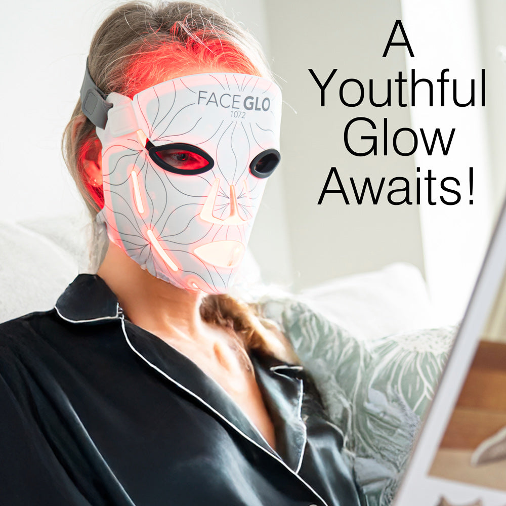 A person wearing the Rio FaceGLO with Photology Chlorophyll Light Masque sits on a couch, tablet in hand. The LED mask delivers clinically proven light at targeted wavelengths. On-screen text reads: A Youthful Glow Awaits!.