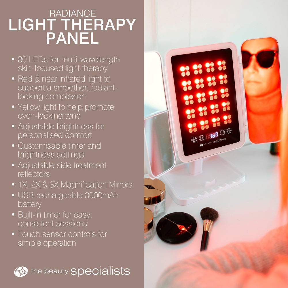 The Rio Radiance Light Therapy Panel, featuring red LED lights for advanced skin care and radiant skin, sits on a table beside orange-tinted goggles. Text highlights features such as adjustable brightness and magnification mirrors.
