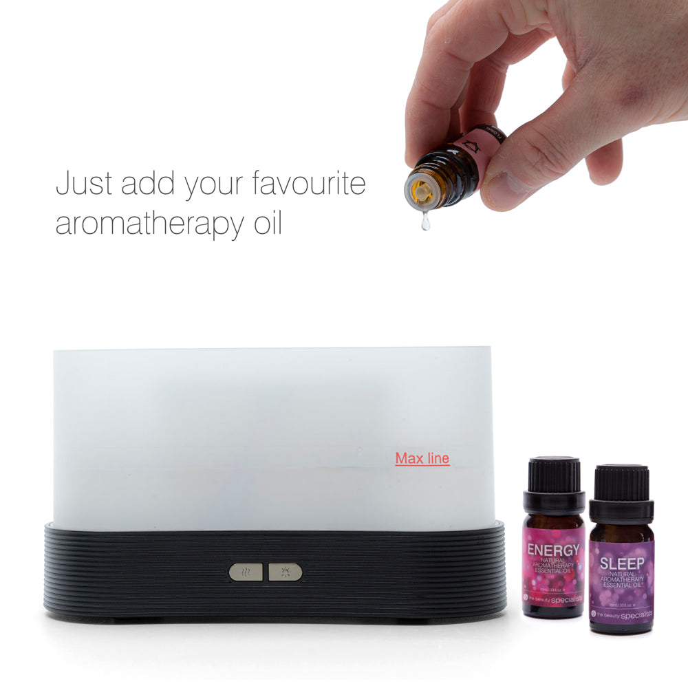 A hand drips essential oils into the sleek Rio ALTA Aroma Diffuser, Humidifier and Night-light. Nearby are bottles labeled ENERGY and SLEEP. Text reads: Just add your favourite aromatherapy oil.