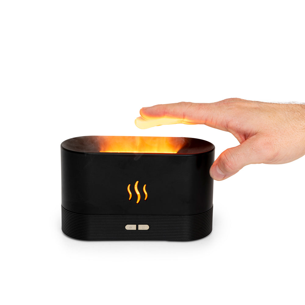 A hand hovers above the Rio ALTA Aroma Diffuser, Humidifier and Night-light, a black rectangular device with steam symbols and an orange flame-like glow, evoking warmth and the comfort of soothing essential oils.