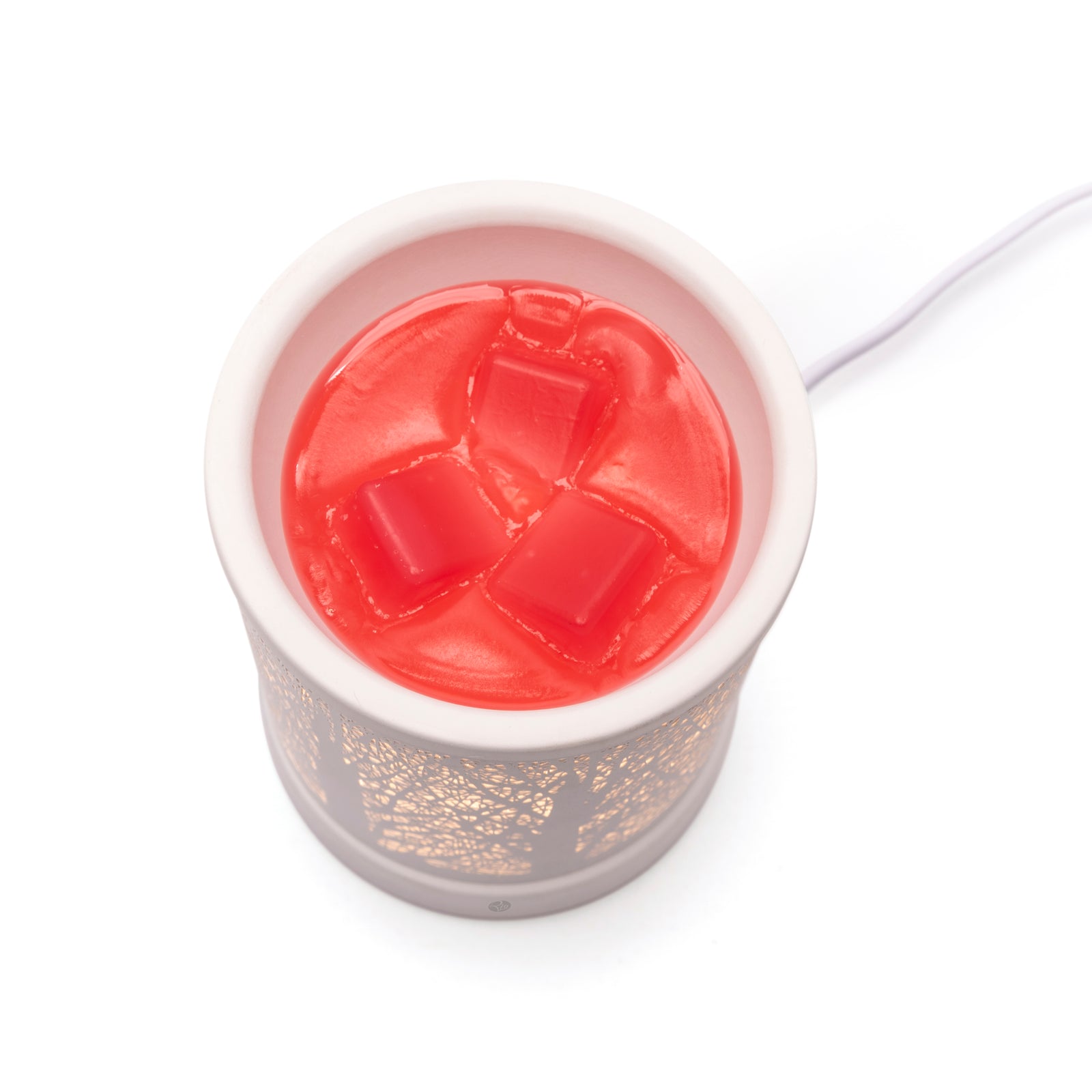 The Rio FORA Wax Melt Burner & Aroma Diffuser Lamp in white, shown from above with melted red wax and three red wax cubes, lets you relax in style as its soothing fragrance fills your space.