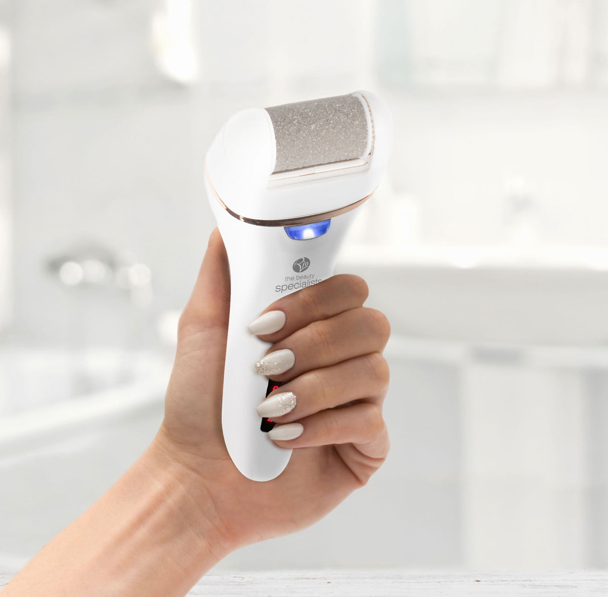 ladies hand holding Go smooth 60 second pedi hard skin remover in bathroom setting 