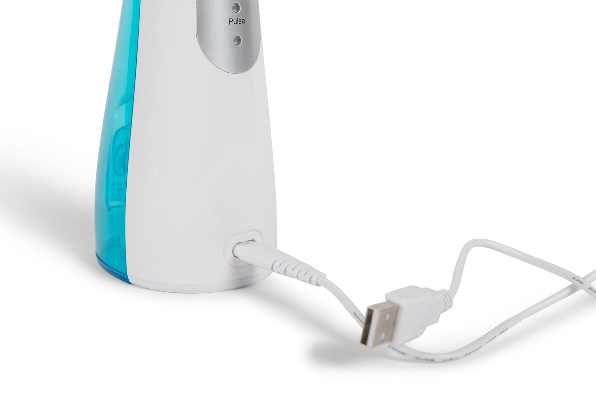 USB charging cable plugged into back of rio water flosser and oral irrigator